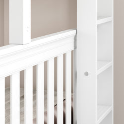 White wooden crib with slatted design and built-in shelves, ideal for a modern nursery.