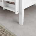 White loft bed with ladder on plush gray carpet.