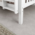 White bunk bed corner with ladder on beige carpet flooring in a children's bedroom.