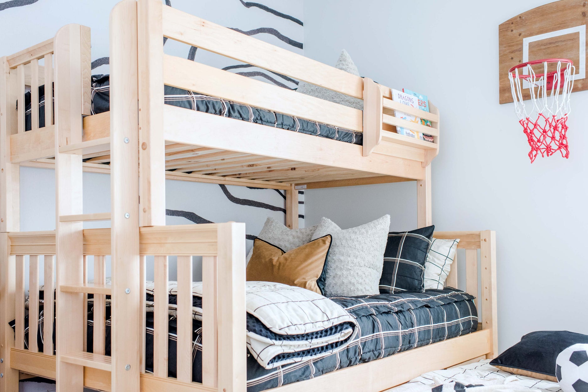 Stylish children's bedroom with modern wooden bunk bed and basketball hoop decor.