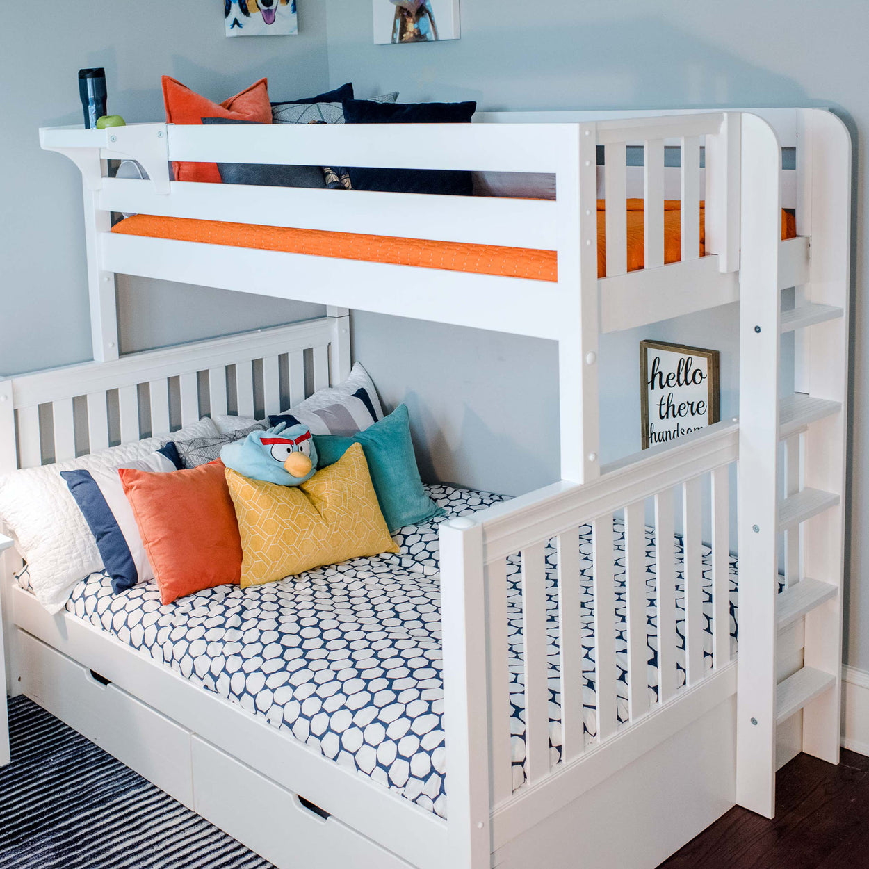 White wooden bunk bed with colorful pillows and an Angry Birds plush toy in a modern kids' bedroom.