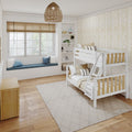 Cozy neutral children's bedroom with white wooden bunk bed, built-in window seat with blue cushions, rattan pendant light, beige chevron wallpaper and hardwood floors
