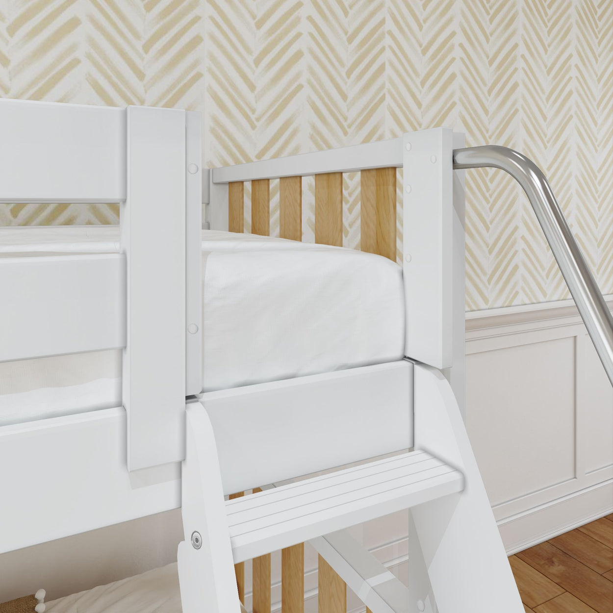 White bunk bed with wooden accents and metal slide in a children's bedroom with chevron wallpaper.