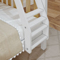 Close-up of white wooden bunk bed ladder with slatted steps, beige textured blanket with pom-pom trim on hardwood floor in kids' bedroom