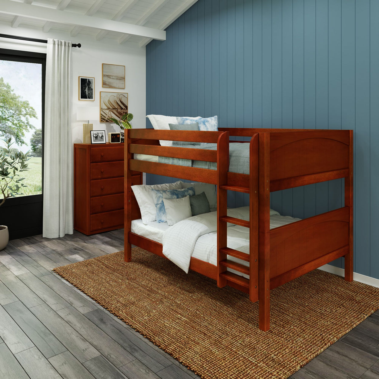 Wooden bunk bed in a cozy bedroom with blue accent wall and natural light.