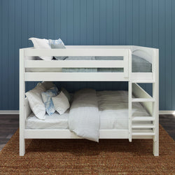 White wooden bunk bed with comfortable pillows and blankets in a modern bedroom featuring a blue paneled wall.