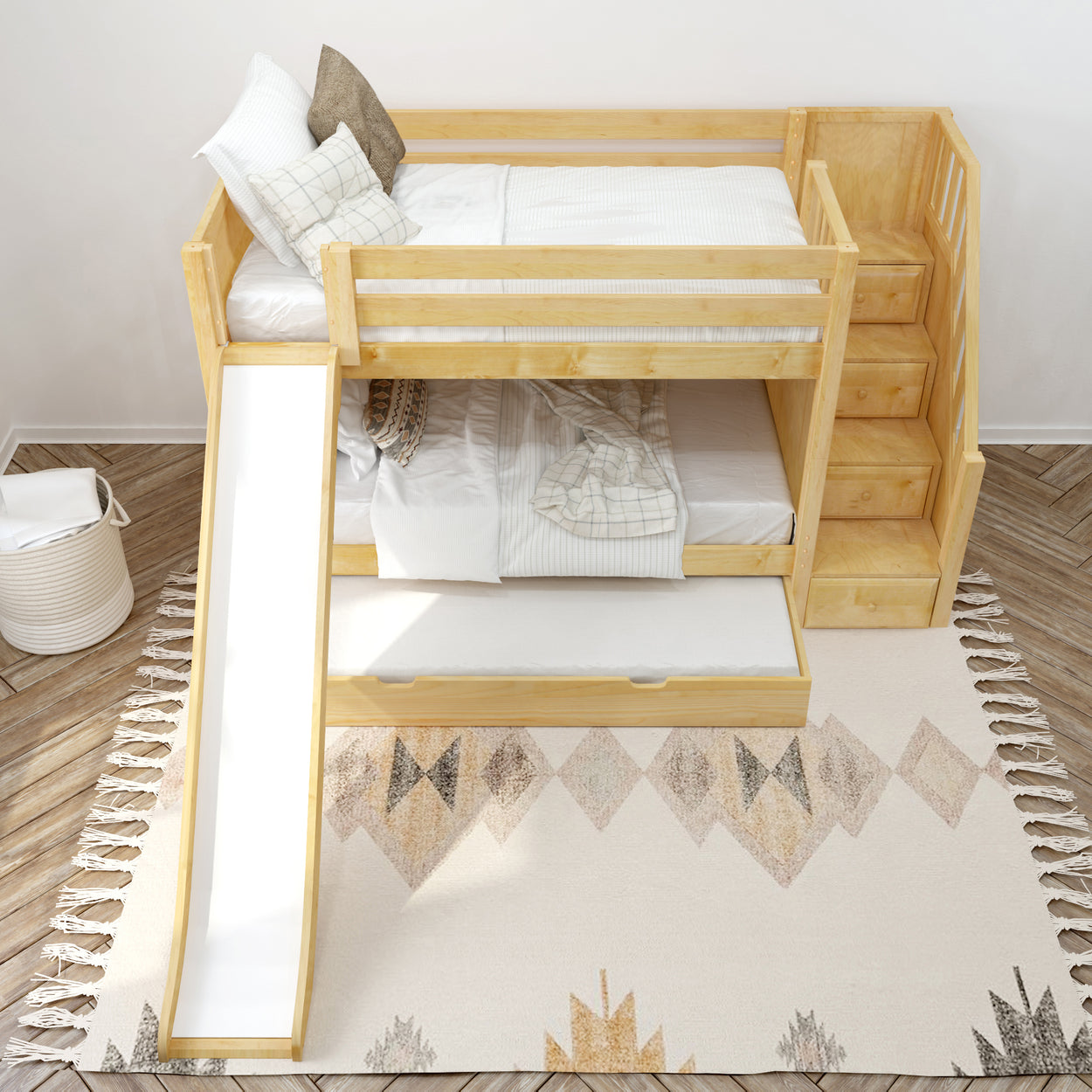 Wooden bunk bed with slide and stairs on a decorative rug in a bright children's room.