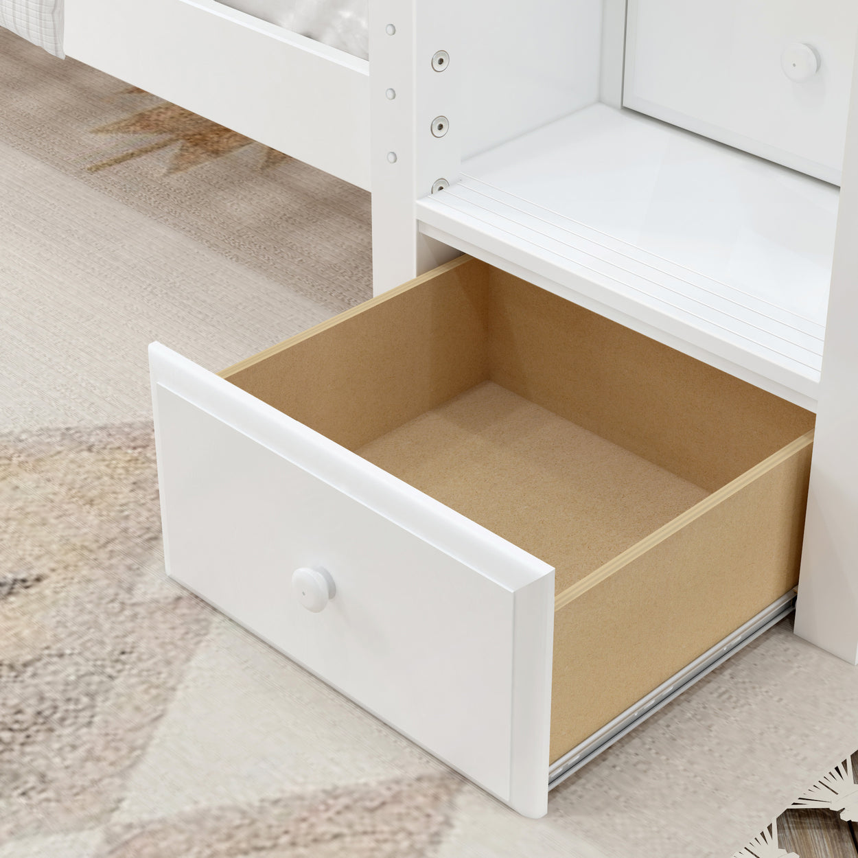 Open wooden drawer in a white cabinet with carpet floor background.