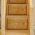 Built-in maple wood under-stair storage drawers with round knobs — custom staircase cabinetry for space-saving wooden drawer organization