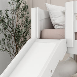 White wooden children's loft bed with slide, featuring soft pink bedding and a decorative plant in a cozy bedroom.