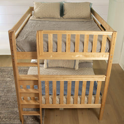 Wooden bunk bed with striped bedding in a cozy bedroom setting.