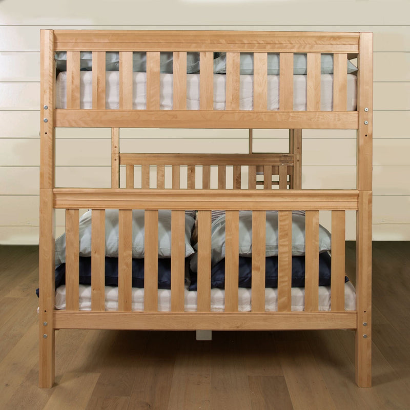 Solid wood twin-over-twin bunk bed with natural finish, slatted guardrails and sturdy posts, mattress and pillows, space-saving design for children's bedrooms