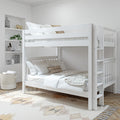 Modern white wooden bunk bed with ladder and guardrail in a neutral kids' bedroom, layered white and beige bedding, built-in shelving with decor, woven storage basket and patterned rug