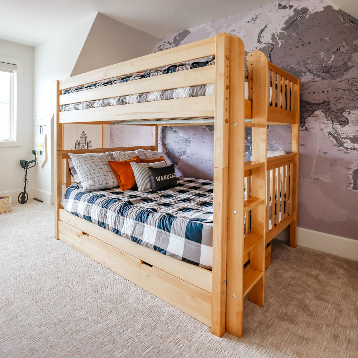 Bunk bed in a cozy kids' room with world map wallpaper and plaid bedding.