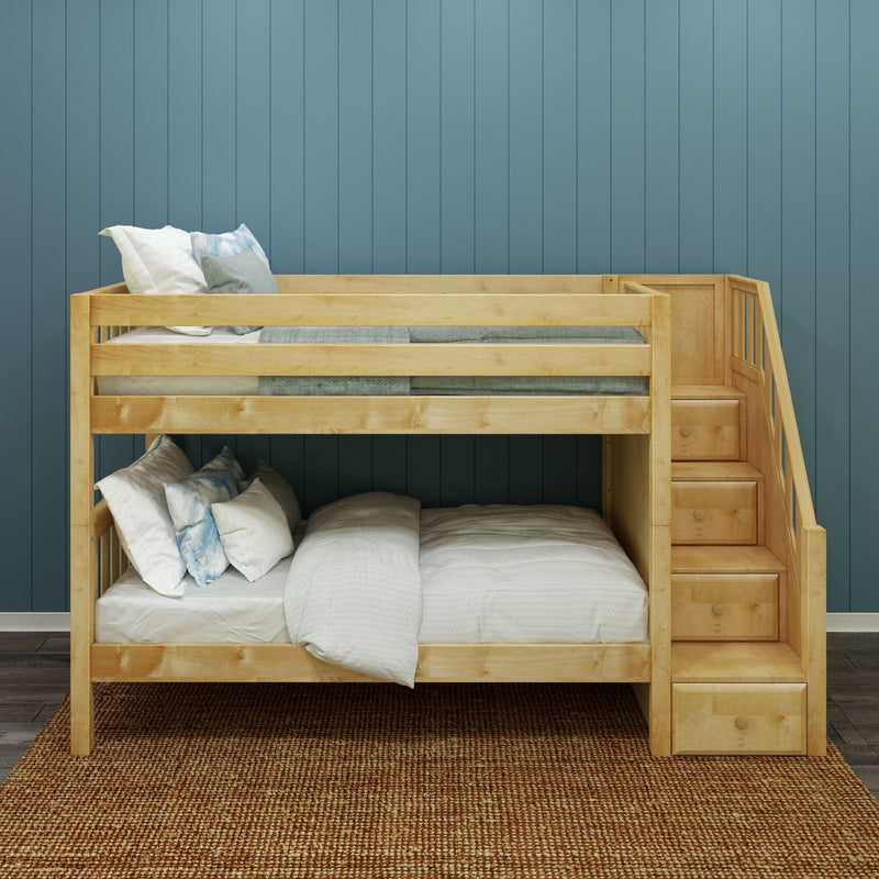 Wooden bunk bed with built-in stairs and storage drawers in kids bedroom, natural wood finish with white and blue bedding against a blue paneled wall on a woven jute rug