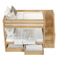 Wooden bunk bed with staircase and storage drawers, featuring comfortable bedding and pillows.
