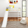 White kids loft bed with slide and ladder, yellow and striped pillows, abstract wall art, large window, hardwood floor and patterned rug
