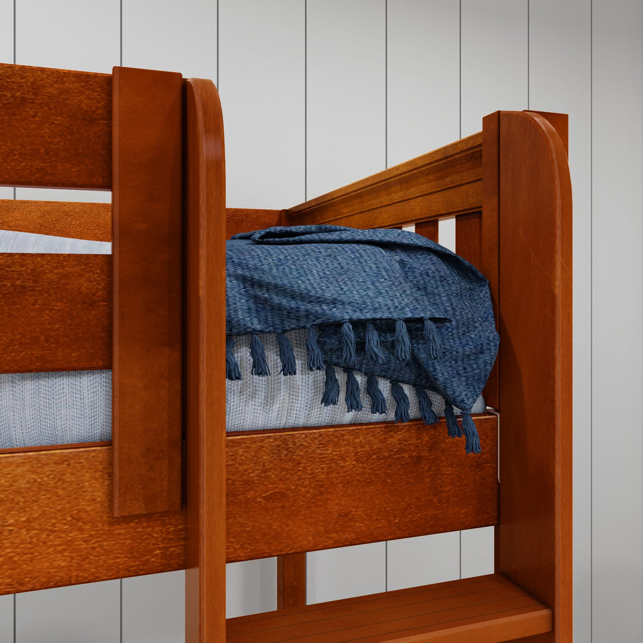 Wooden bunk bed with blue woven blanket in cozy bedroom setting.