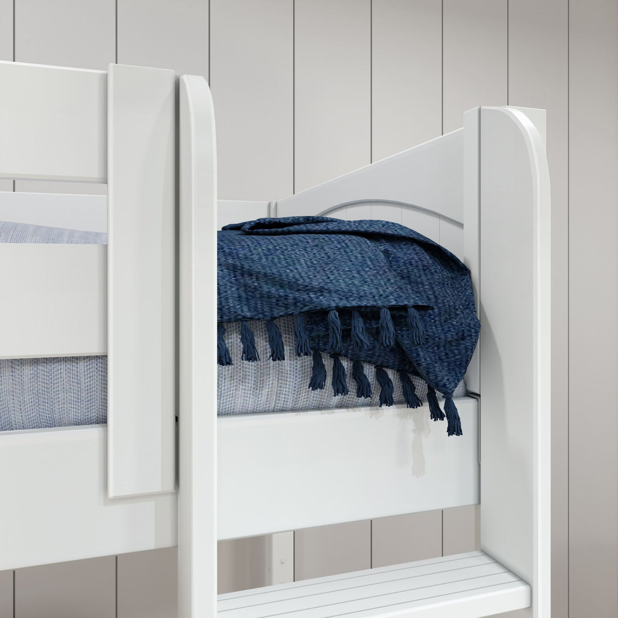 White wooden bunk bed with blue textured blanket in modern bedroom setting.