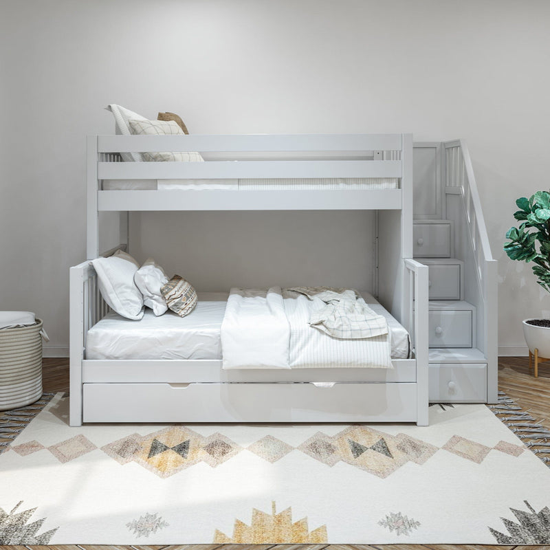 White wooden bunk bed with staircase and built-in storage drawers in a bright modern kids' bedroom, neutral bedding, geometric area rug and potted plant