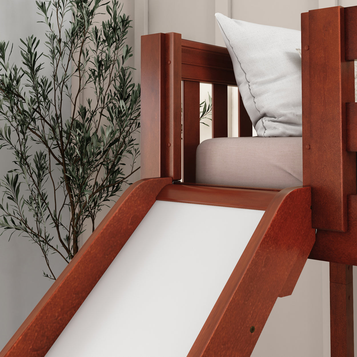 Wooden indoor slide with cushion and green plant backdrop for modern playroom design.