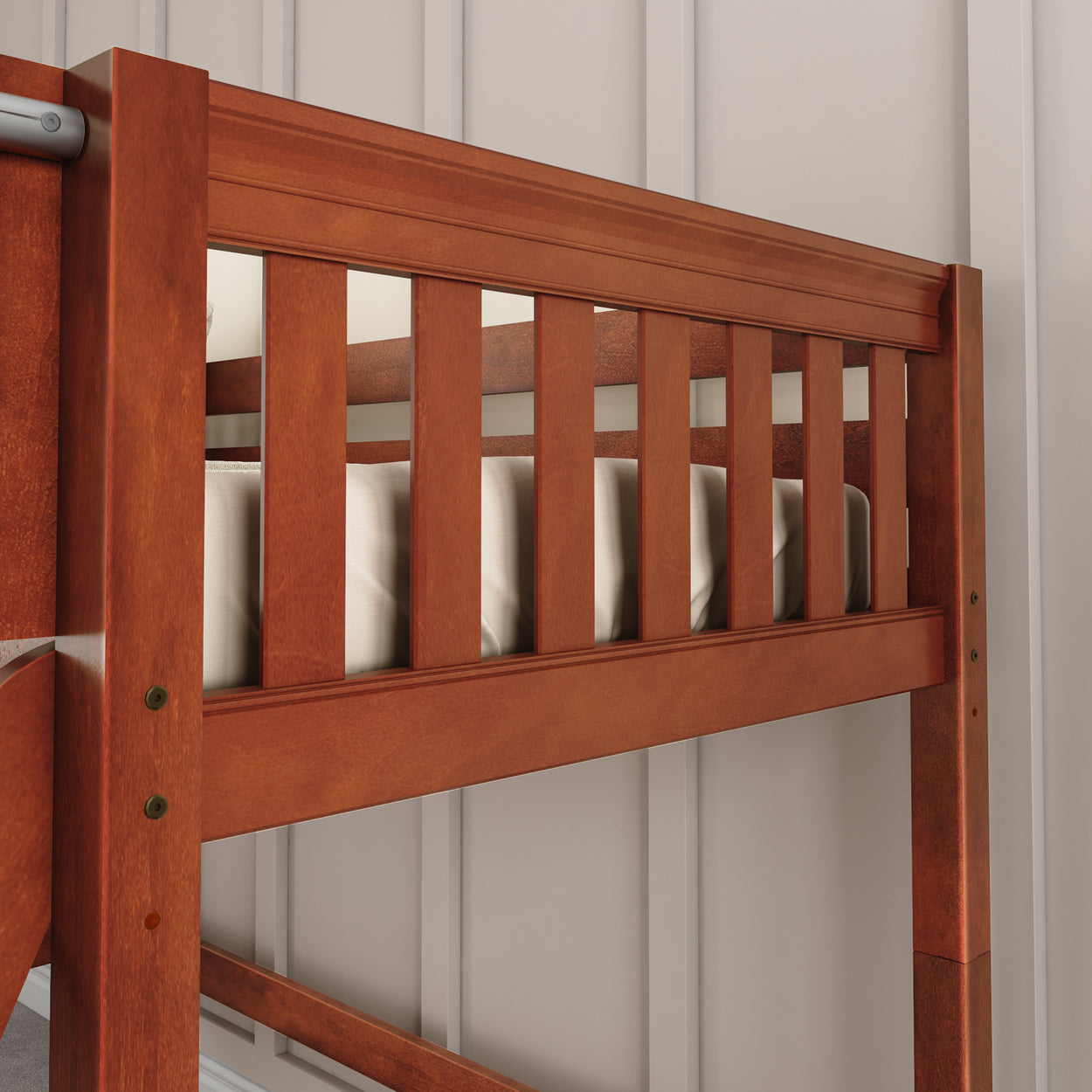 Wooden bunk bed rail detail with beige wall background.