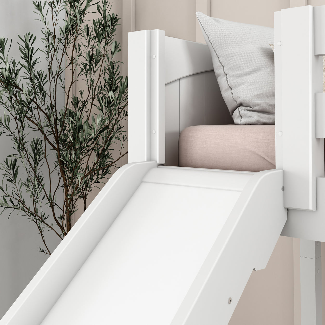 White indoor slide connected to a children's loft bed with cushions, next to a decorative plant.