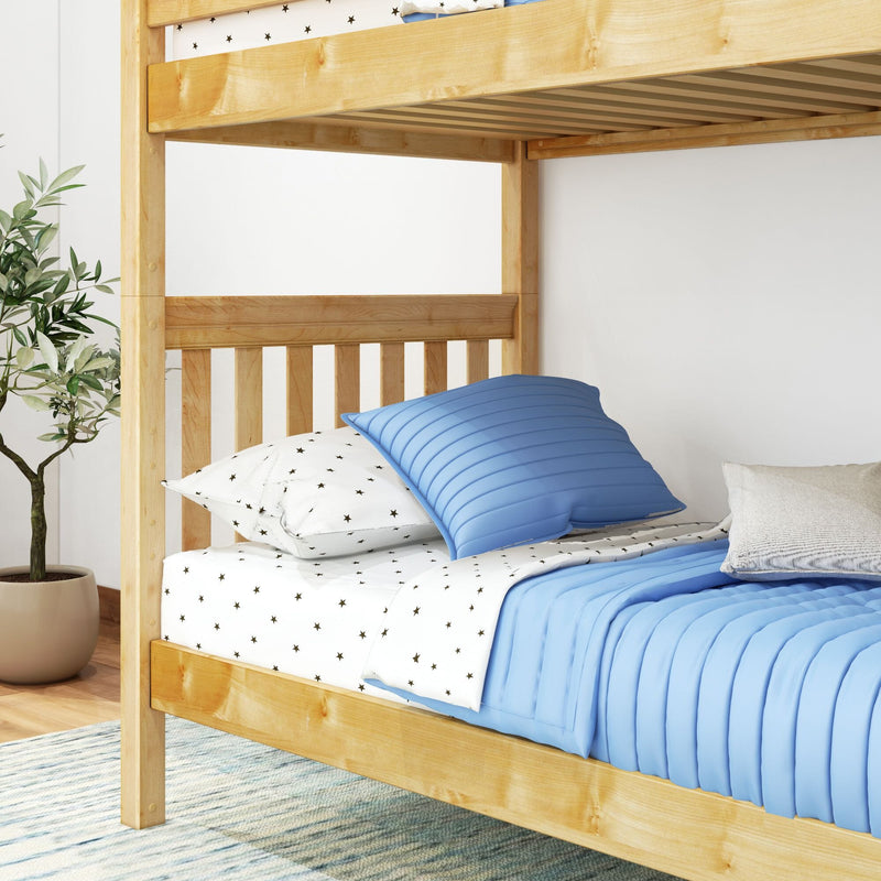 Light natural wood bunk bed styled with blue quilt, star-print sheets and pillows in a modern kids' bedroom with potted plant
