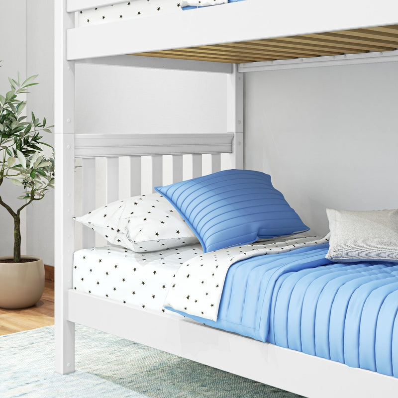 White wooden bunk bed with blue quilted pillows and star-print sheets in a bright kids' bedroom with potted plant