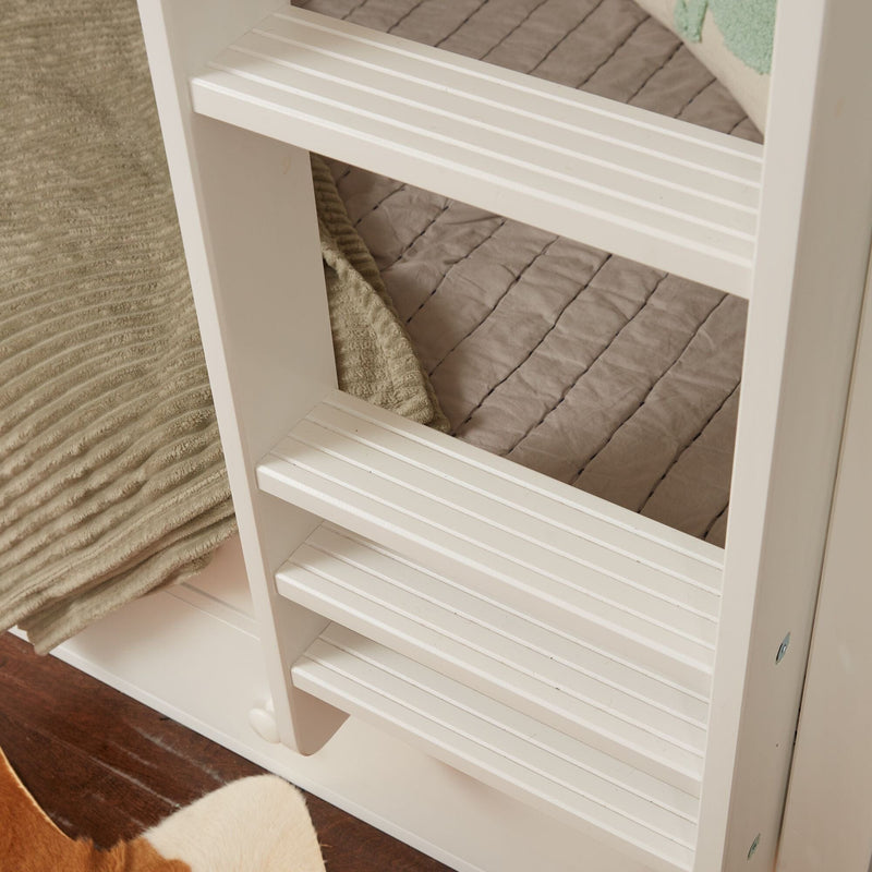 White slatted wooden shelving unit with folded beige towel and quilted blanket on hardwood floor, bathroom or entryway storage organizer