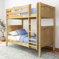 Solid wood twin-over-twin bunk bed with natural finish, built-in ladder and safety rails, styled with blue quilted bedding and star-patterned sheets in a modern kids' bedroom
