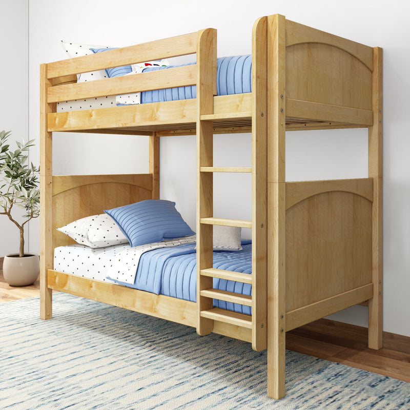 Solid wood twin-over-twin bunk bed with natural finish, built-in ladder and safety rails, styled with blue quilted bedding and star-patterned sheets in a modern kids' bedroom