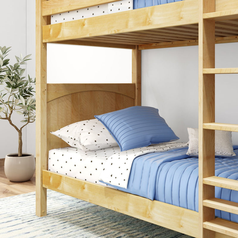Natural wood bunk bed with ladder, blue quilt and star-print sheets in a modern kids' bedroom with potted plant
