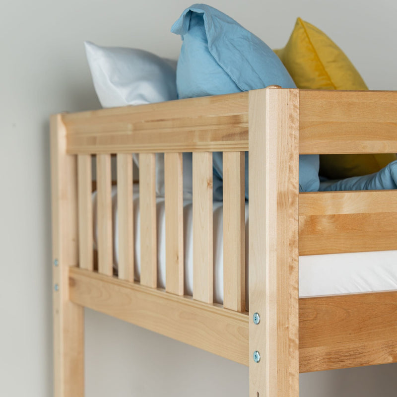 Solid wood bunk bed with natural finish, slatted guardrail and blue and yellow pillows in kids' bedroom