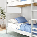 White wooden bunk bed with ladder and natural wood slats, blue quilted pillows and star-print sheets in a modern kids' bedroom