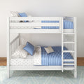 White wooden bunk bed with blue quilted bedding, star-print sheets and pillows, side ladder in a modern kids' bedroom