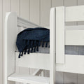 White wooden bunk bed close-up with navy blue tasseled throw and gray mattress against light shiplap wall in a modern kids' bedroom