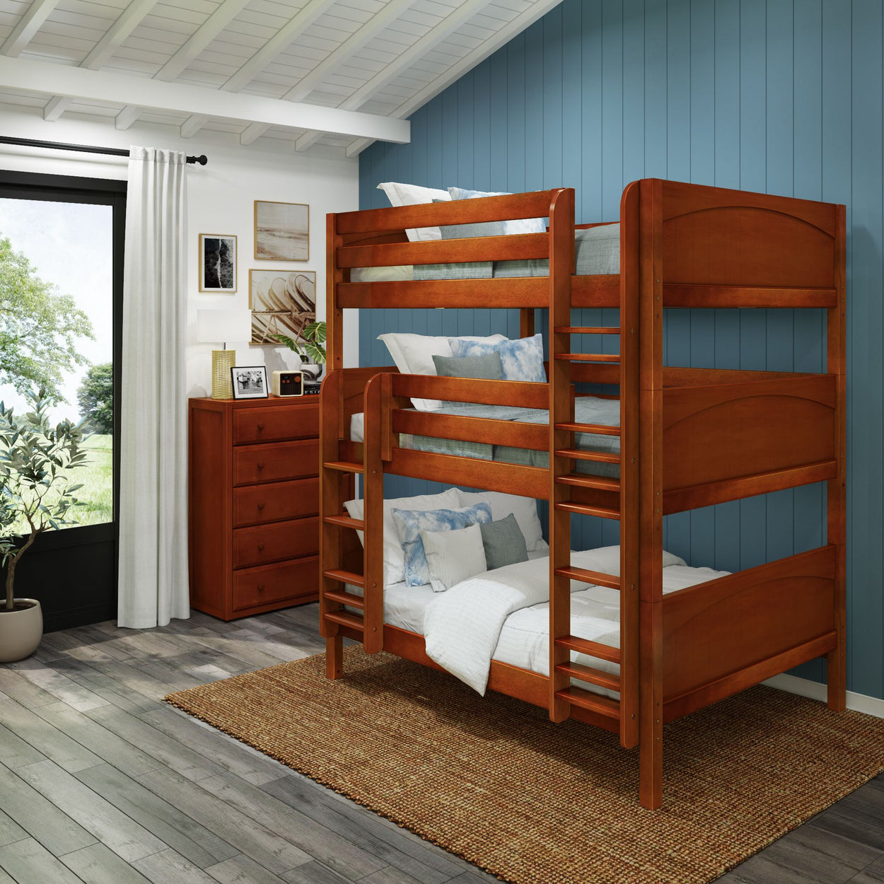Modern wooden bunk bed in cozy bedroom with blue accent wall and chest of drawers.