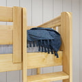 Close-up of natural pine bunk bed railing with blue textured tassel throw blanket, modern farmhouse kids' bed