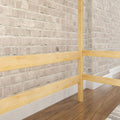 Whitewashed exposed brick interior wall with light wood railing and hardwood floor, modern industrial home detail