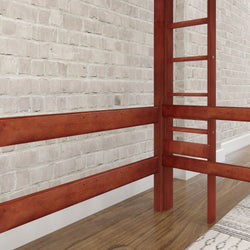 Wooden loft bed frame with ladder against a white brick wall.