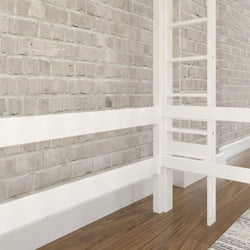 White wooden loft bed frame against a rustic brick wall in a modern bedroom with wood flooring.