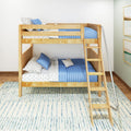 Wooden twin-over-twin bunk bed with blue quilted bedding, star-print sheets and ladder in a bright modern kids' bedroom