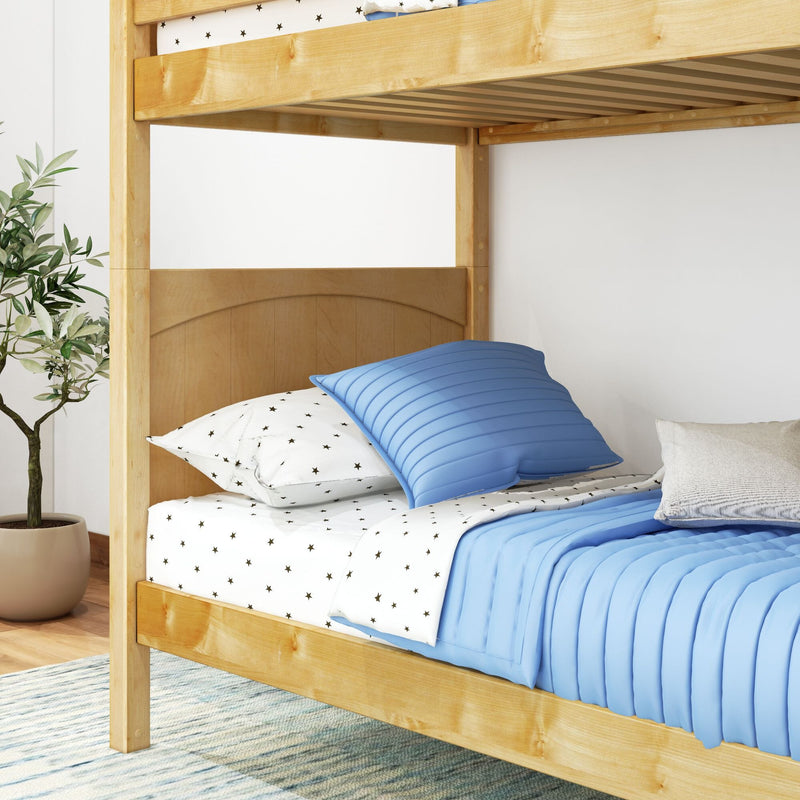 Natural wood bunk bed with blue bedding and star-print sheets in a kids' bedroom, potted plant nearby