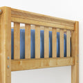Close-up of natural maple finish solid wood bunk bed guardrail and slatted headboard with blue mattress bedding