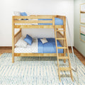 Natural wood bunk bed with ladder and blue quilted bedding, star-print sheets and pillows in a modern kids' bedroom