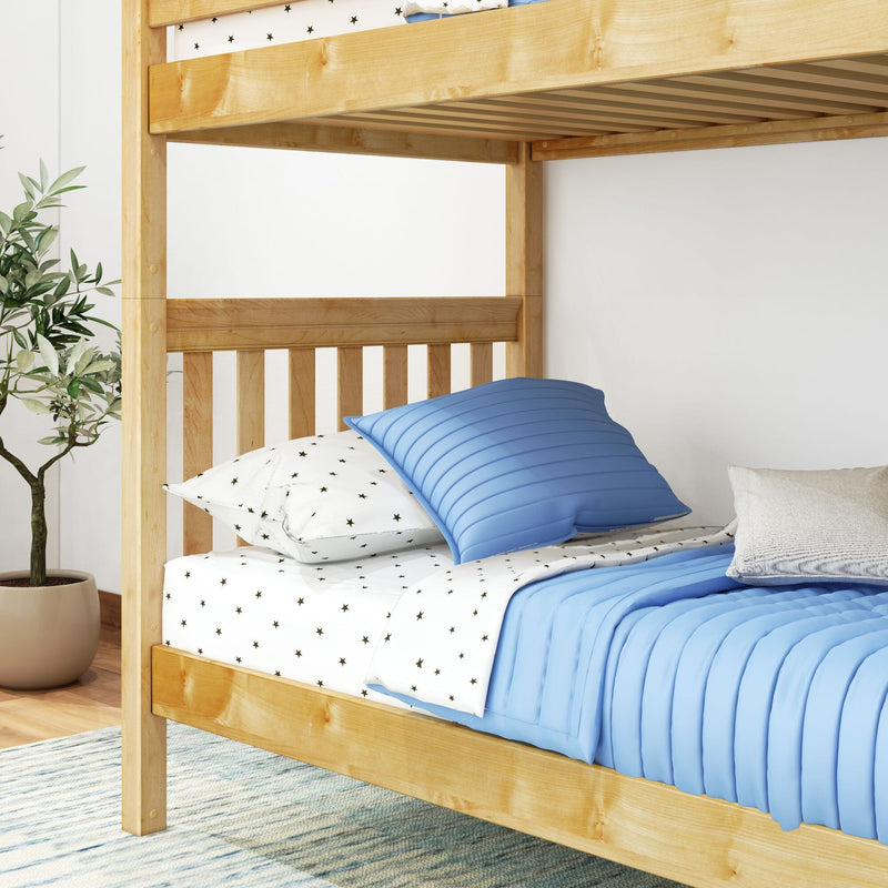 Natural wood twin bunk bed with slatted headboard, blue quilted pillows and star-print sheets in a modern kids' bedroom