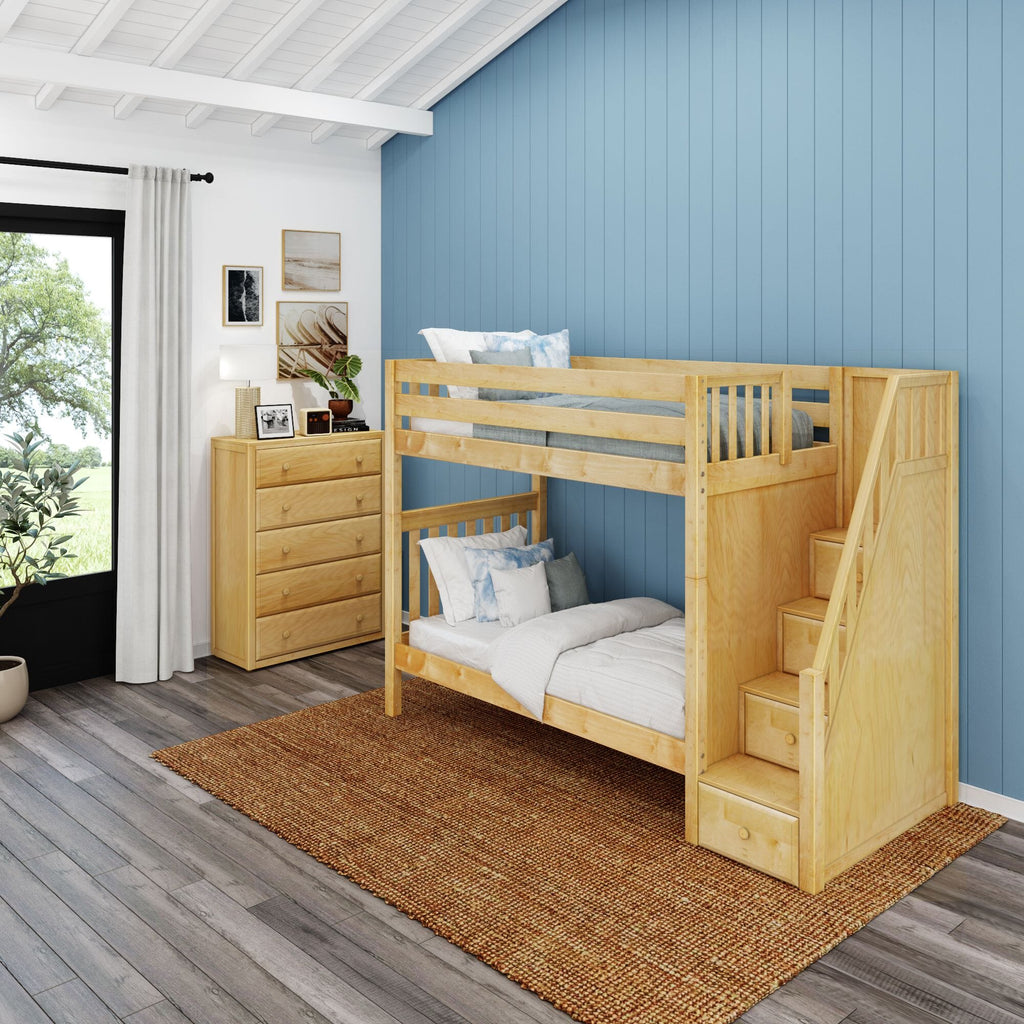 Light natural wood bunk bed with built-in storage stairs in a modern kids' bedroom with blue vertical accent wall, dresser and window