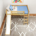 Top-down view of a wooden kids loft bed with slide and ladder, blue ribbed mattress, star-patterned bedding, colorful wall art and geometric rug in a modern children's bedroom