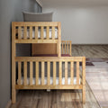 Wooden bunk bed in minimalist kids bedroom with gray pillow, white mattress and hardwood floor